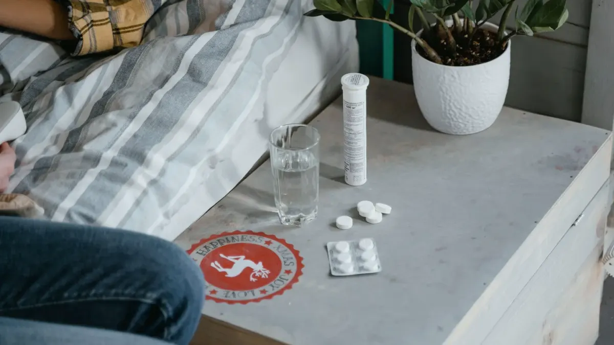A dog looking up at a pill bottle left open on a kitchen counter