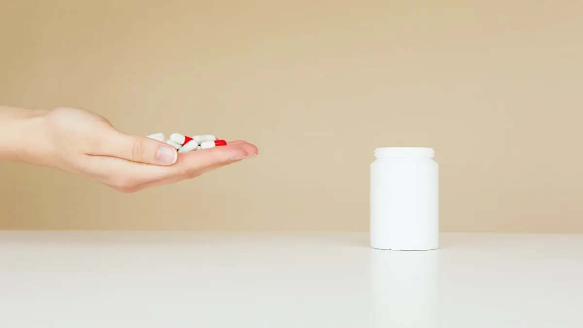 A dog owner comparing a supplement bottle and a dog treat pouch on a kitchen counter