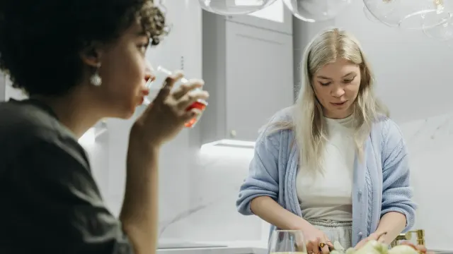 A person reading the ingredient label on a dog supplement bottle in a kitchen