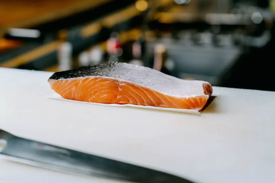 Raw salmon fillet being checked with a meat thermometer before cooking